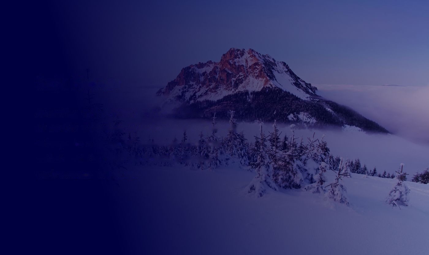 Snow-covered High Tatras peak rising above a sea of fog at dusk